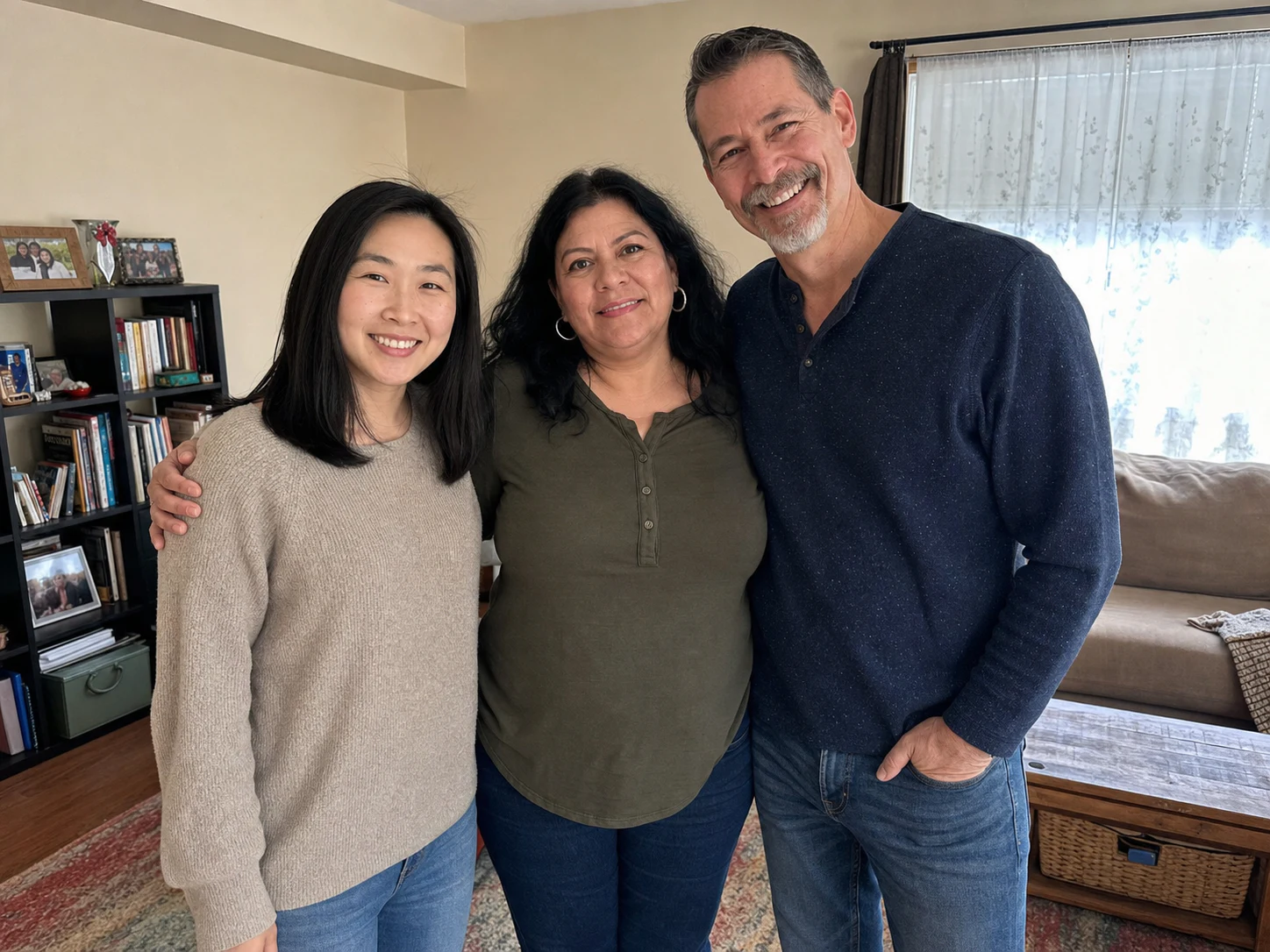Three adult family members standing closely together in a living room